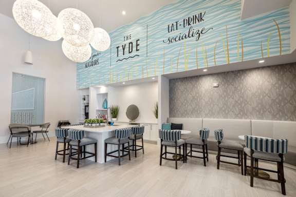 a kitchen with white cabinets and a large island with a sink and two stools