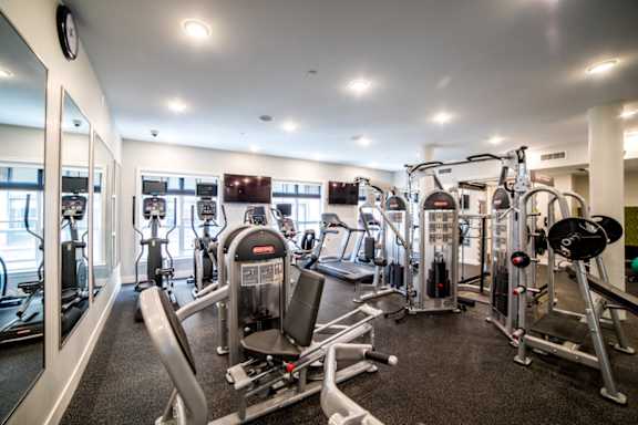 A gym with a variety of exercise equipment including treadmills, stationary bikes, and weight machines at The Foundry Apartments , South Bend, IN, 46617