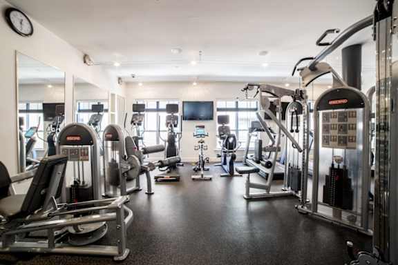 A gym with a variety of equipment including treadmills, weights, and exercise machines at The Foundry Apartments , South Bend, IN, 46617
