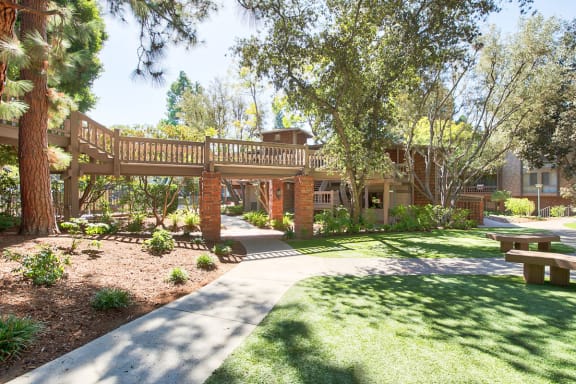 a walkway leading to a building with a wooden deck at The Meadows Apartments, Culver City , CA 90230