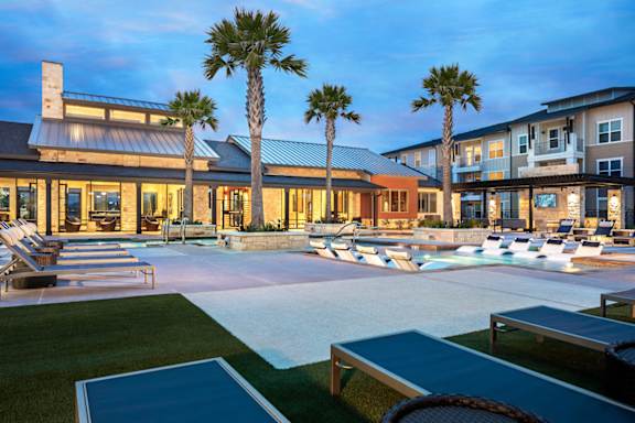 Upscale pool deck offering in-water relaxation areas, ample lounge seating, and a sophisticated resort atmosphere.