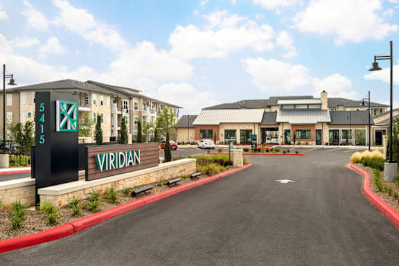 Elegant community entrance with contemporary design, manicured grounds, and a convenient drive-up arrival experience.