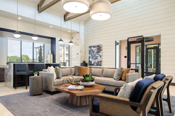 Elegant resident lounge featuring soaring ceilings, designer furnishings, and comfortable spaces to gather or unwind.
