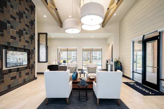 Upscale resident clubhouse featuring stylish lounge seating, vaulted ceilings, and abundant natural light throughout.