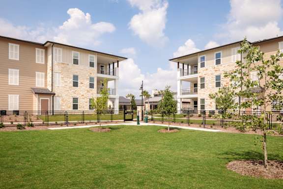 Beautiful apartment community featuring spacious green spaces, modern architecture, and thoughtfully landscaped grounds.