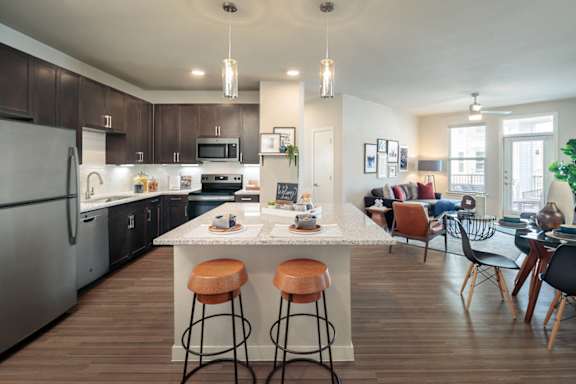 Modern open-concept apartment featuring a spacious kitchen with a large island, stainless steel appliances, and stylish finishes.