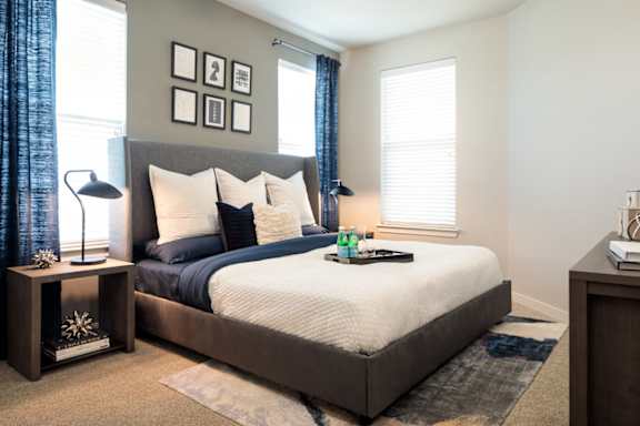 Spacious bedroom featuring large windows, plush carpeting, and contemporary finishes for a comfortable retreat.