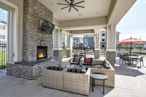Covered Lounge with Cozy Fireplace by Pool at El Paso County Apartments Near I-25