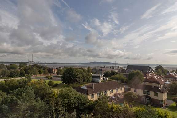an aerial view of a neighborhood with houses and trees and the ocean in the background