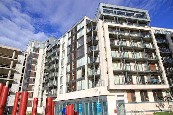 a large apartment building with many balconies and a blue sky