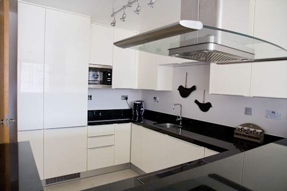 a white kitchen with black counter tops and white cabinets