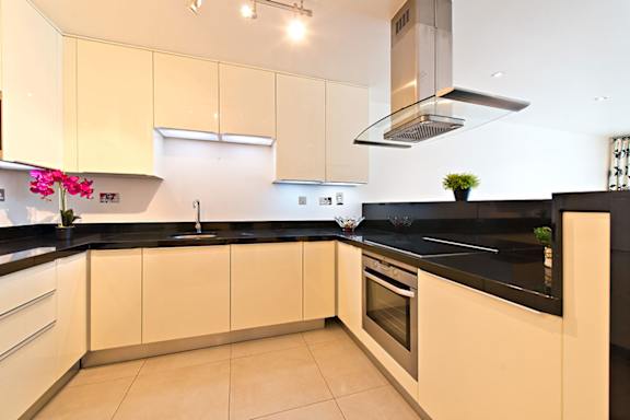 a kitchen with black counter tops and white cabinets