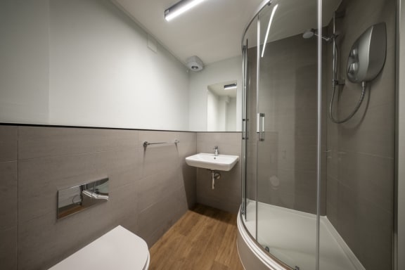 a bathroom with a shower and a sink and a toilet