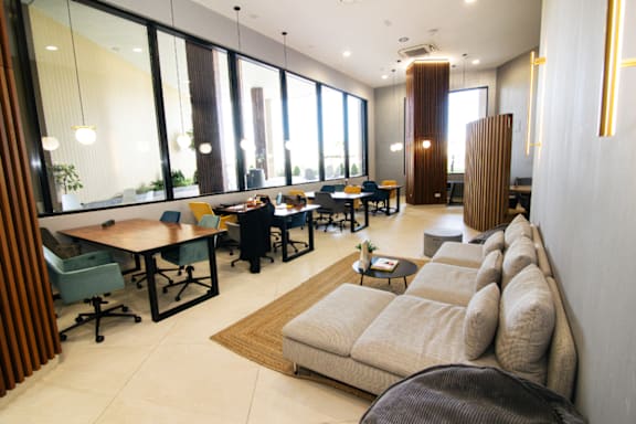 a living room filled with furniture and large windows