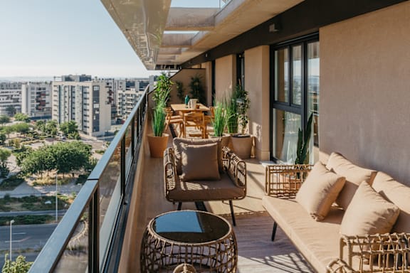 a balcony with furniture and a view of the city
