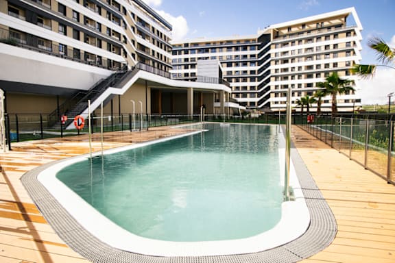 a swimming pool with a building in the background