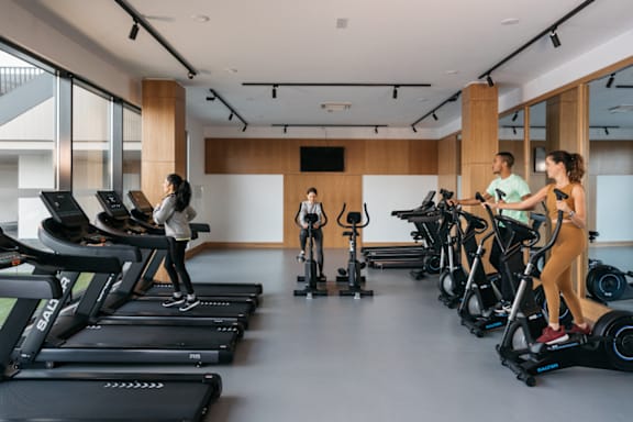 a group of people exercising on treadmills in a gym