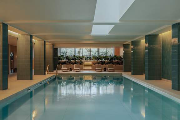 A large indoor swimming pool with a glass bottom.