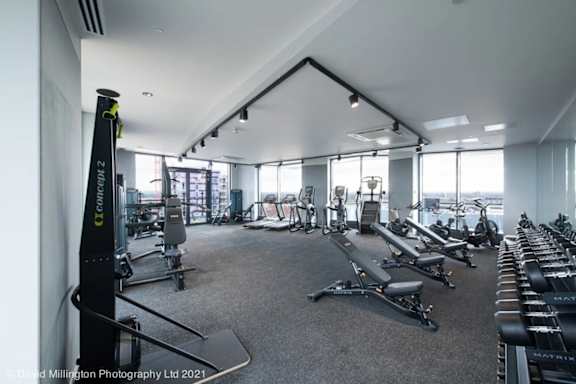 spacious gym with cardio equipment and views of the city at Vox Apartments, Manchester, M15 4YD