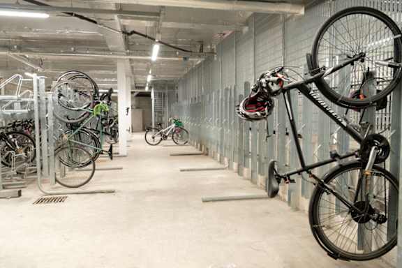 a bike hanging from a wall in a parking garage at The Trilogy Apartments, Manchester, M15 4RU