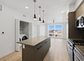 Thumbnail 14 of 51 - A modern kitchen with a large island and stainless steel appliances at Brickside Heights, Millcreek, UT, 84106