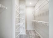 Thumbnail 7 of 8 - a walk in closet with built-in wire shelves and hanging space