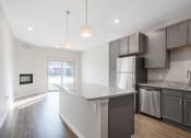 Thumbnail 1 of 8 - a open-concept kitchen with stainless steel appliances and granite counter tops next to a living room
