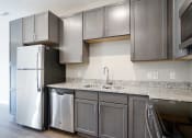 Thumbnail 2 of 8 - a kitchen with stainless steel appliances and grey cabinets
