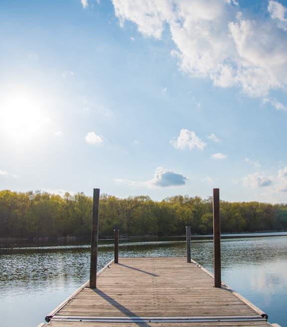 a dock on a lake under a blue sky