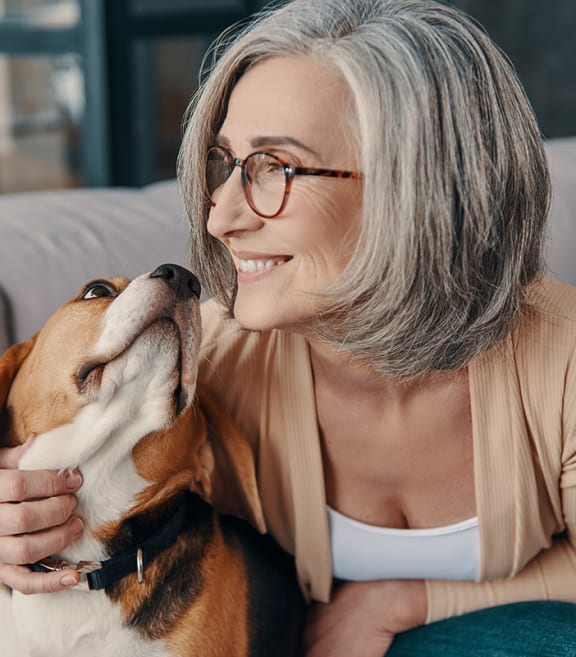 a woman sitting on a couch with her dog