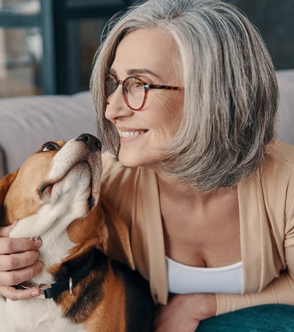 a woman sitting on a couch with her dog at Studebaker Lofts, South Bend, IN, 46601