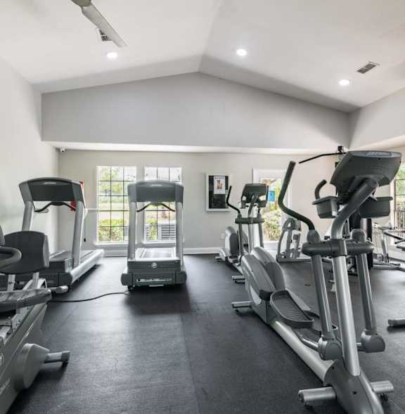 A spacious gym with treadmills, elliptical machines, and other exercise equipment.