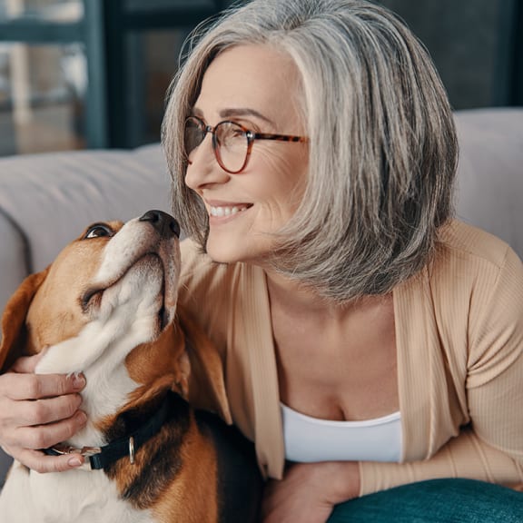 a woman sitting on a couch with her dog