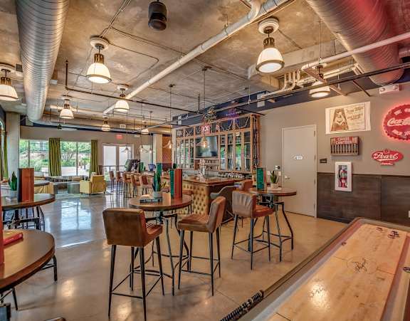 Discovery at the Realm Apartments Community Lounge with Shuffleboard and bar seating
