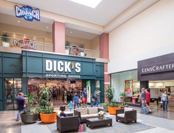 people walking in a shopping mall with dicks sporting goods