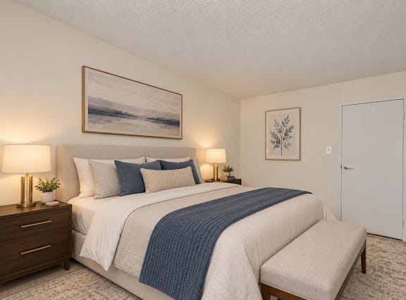 A bedroom with a large bed and a painting on the wall.