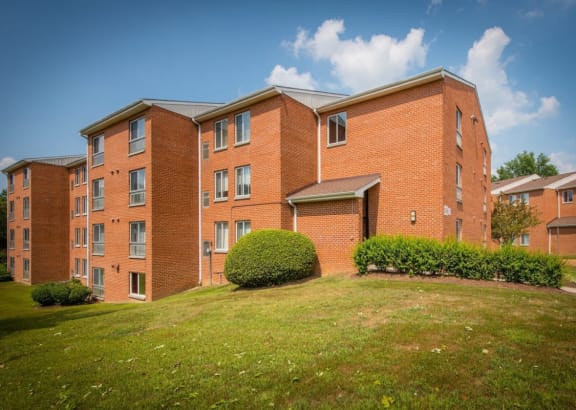 a large brick building with a green lawn in front of it
