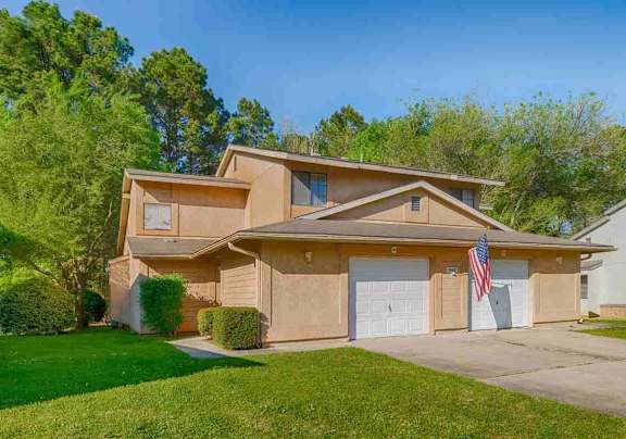 A house with a garage and an American flag hanging on it.