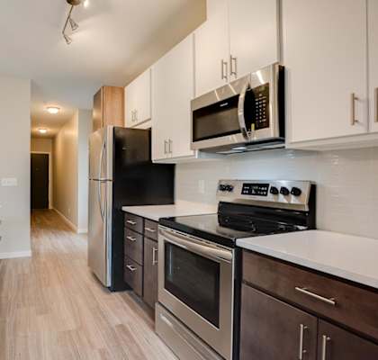 A kitchen with an oven, microwave, and island with a sink