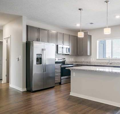 an empty kitchen with stainless steel appliances and a island