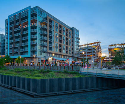 A modern building with a green roof is situated next to a body of water. at Dock 79, Washington