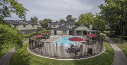 Sierra Glen apartments pool and spa area with tables and sun umbrellas 