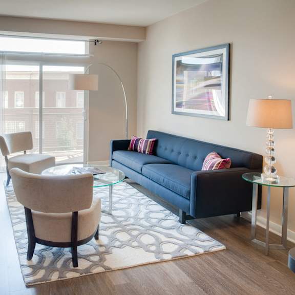 an open concept living room and dining area with a white dining table and rattan chairs