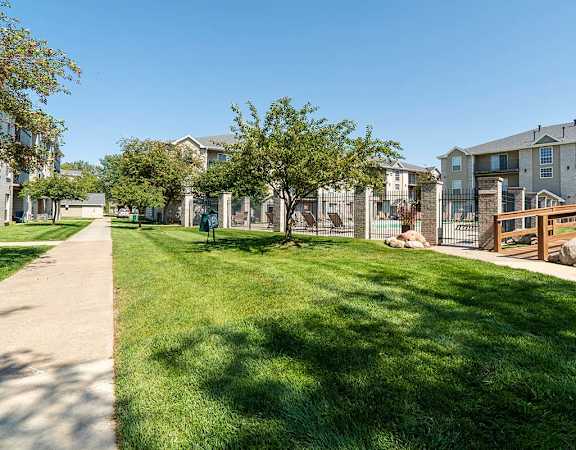 Large green space with walking path in the middle of apartment community
