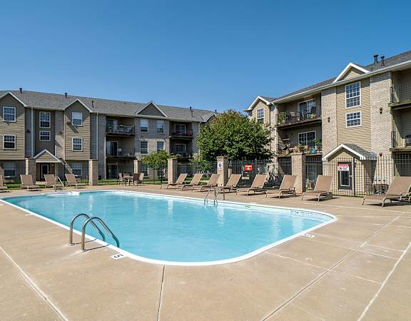 A large swimming pool in front of apartment buildings.