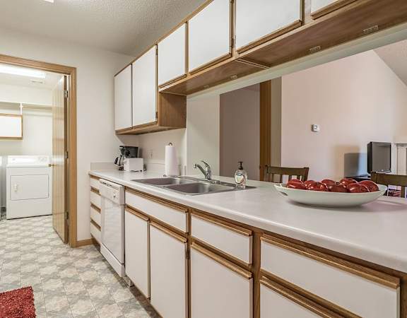 a kitchen with white cabinets and a sink      and a door