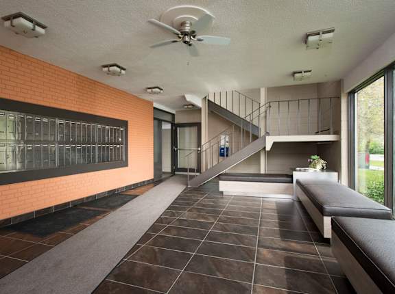 A long hallway with a bench and a fan.