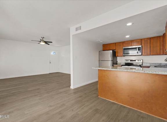 an empty living room with a kitchen and a counter top