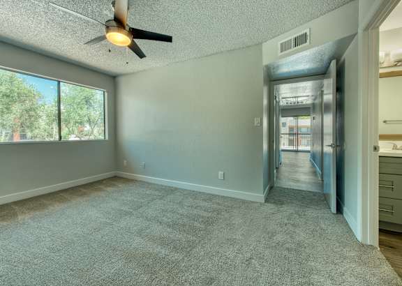 A room with a ceiling fan and a carpeted floor. at Tela Verde, Glendale, AZ