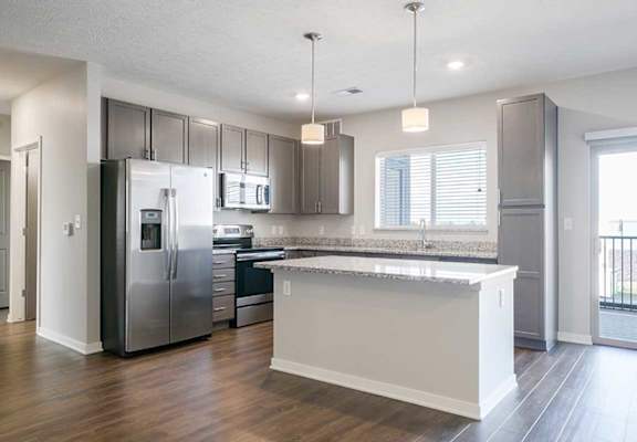 an empty kitchen with stainless steel appliances and a island